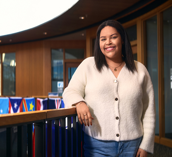 女性が窓の横で腕を組んで立っている